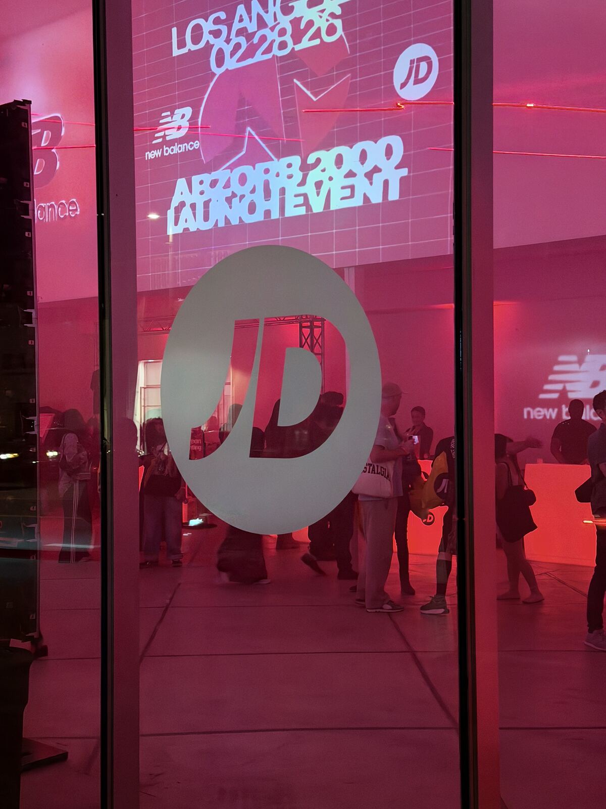 Dramatic red-lit booth signage and merchandise display at an event venue